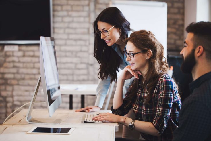 Equipe trabalhando para analisar dados da operação da empresa em frente ao computador