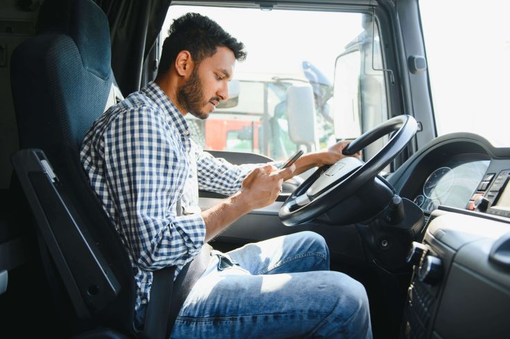 Homem utilizando telefone em caminhão