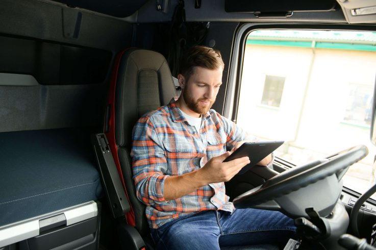 Motorista consultando dados de roteirização gerados por inteligência artificial no tablet.