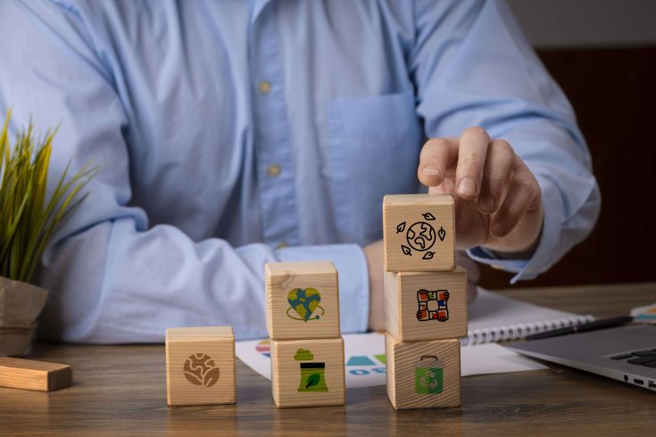 homem de negócios segurando pilares das certificações sustentáveis para empresas