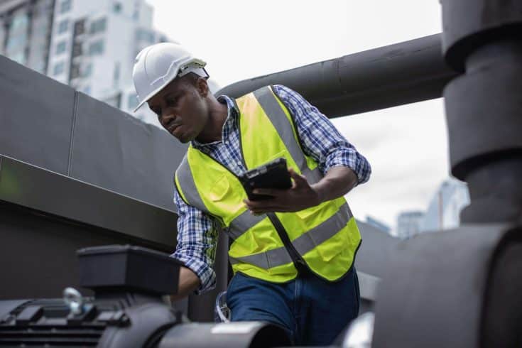 Engenheiro trabalhando na manutenção de equipamento em uma fábrica.